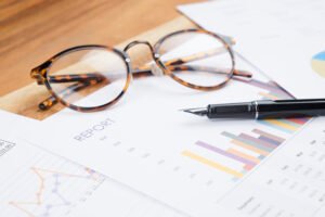 wood working table business report analyze chart glasses pen